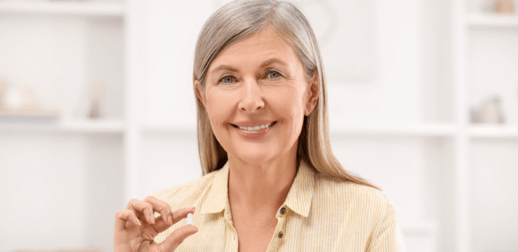 Woman smiling holding a pill